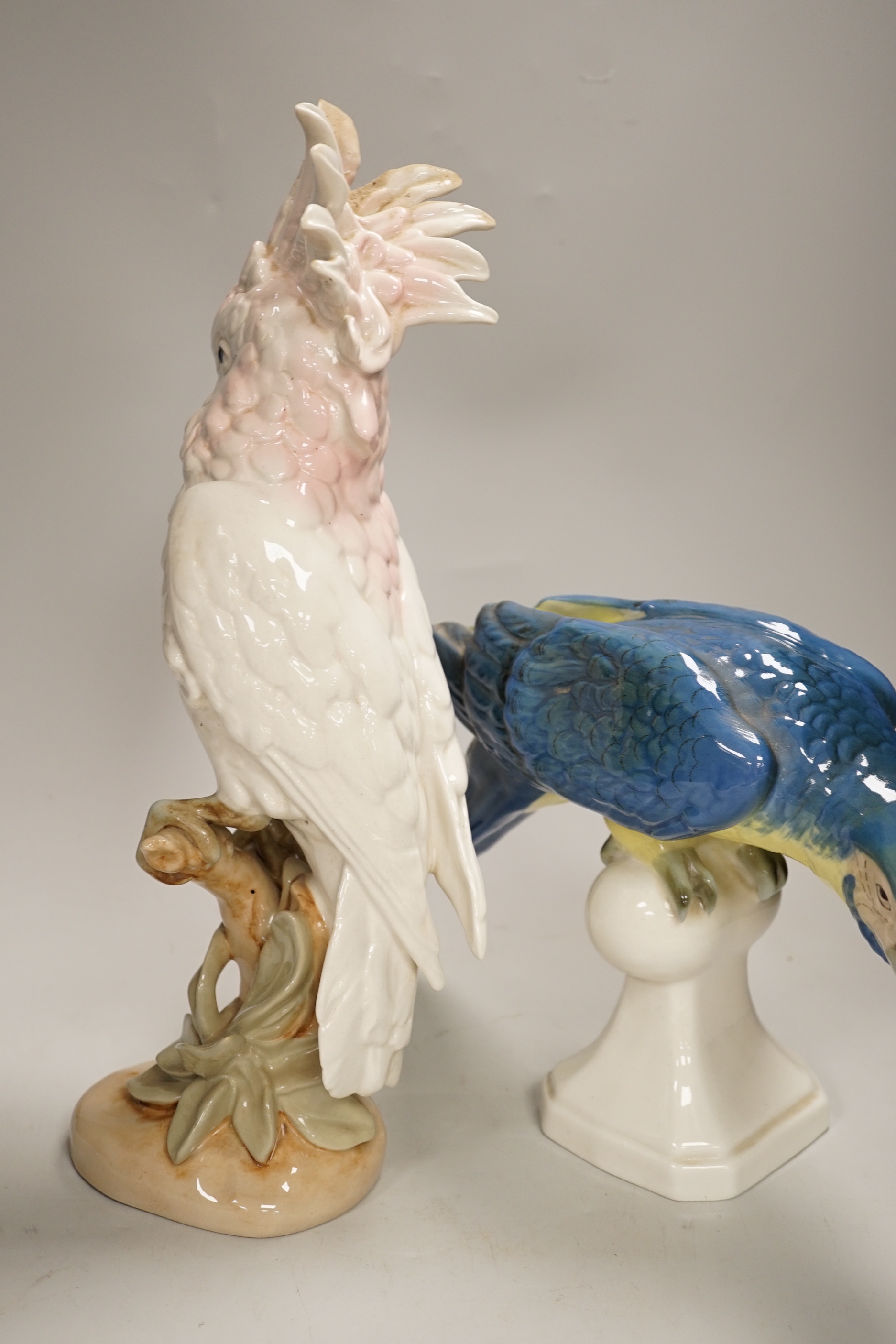 Two Royal Dux parrots and a Beswick parrot, the largest 40cm high